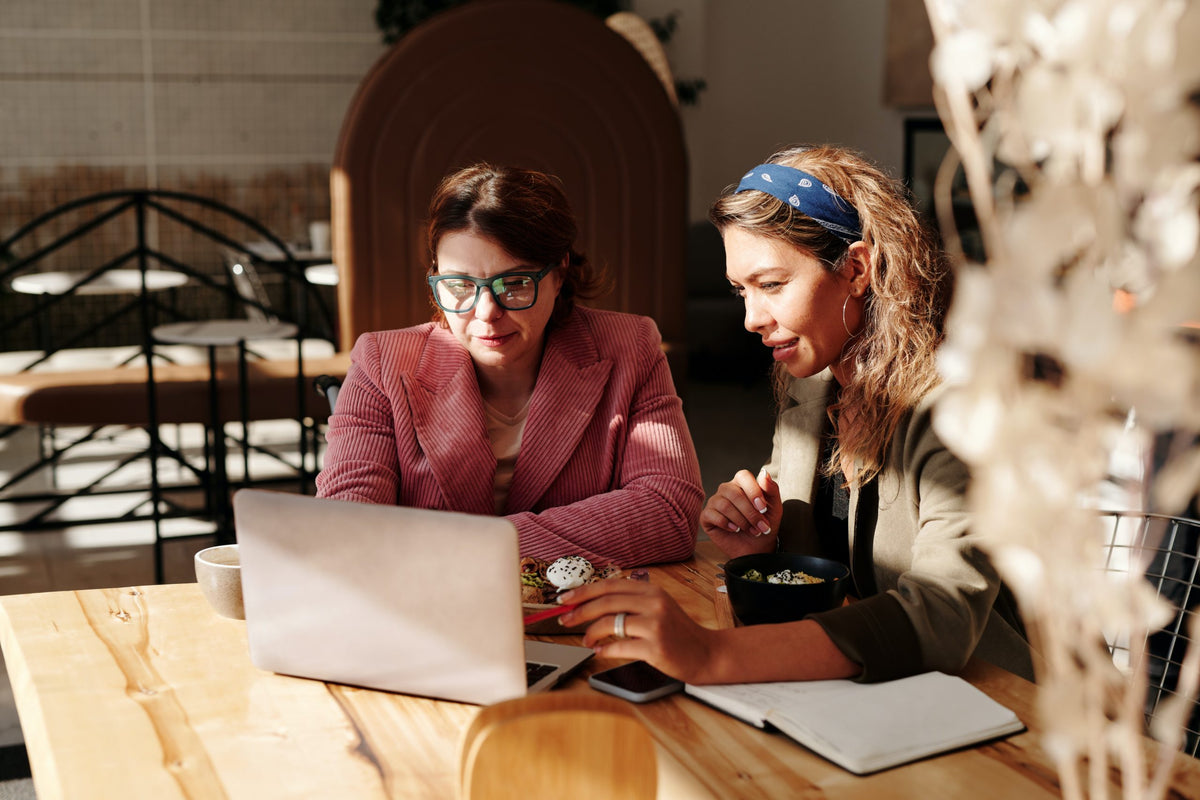 Employees discuss finances over laptop.