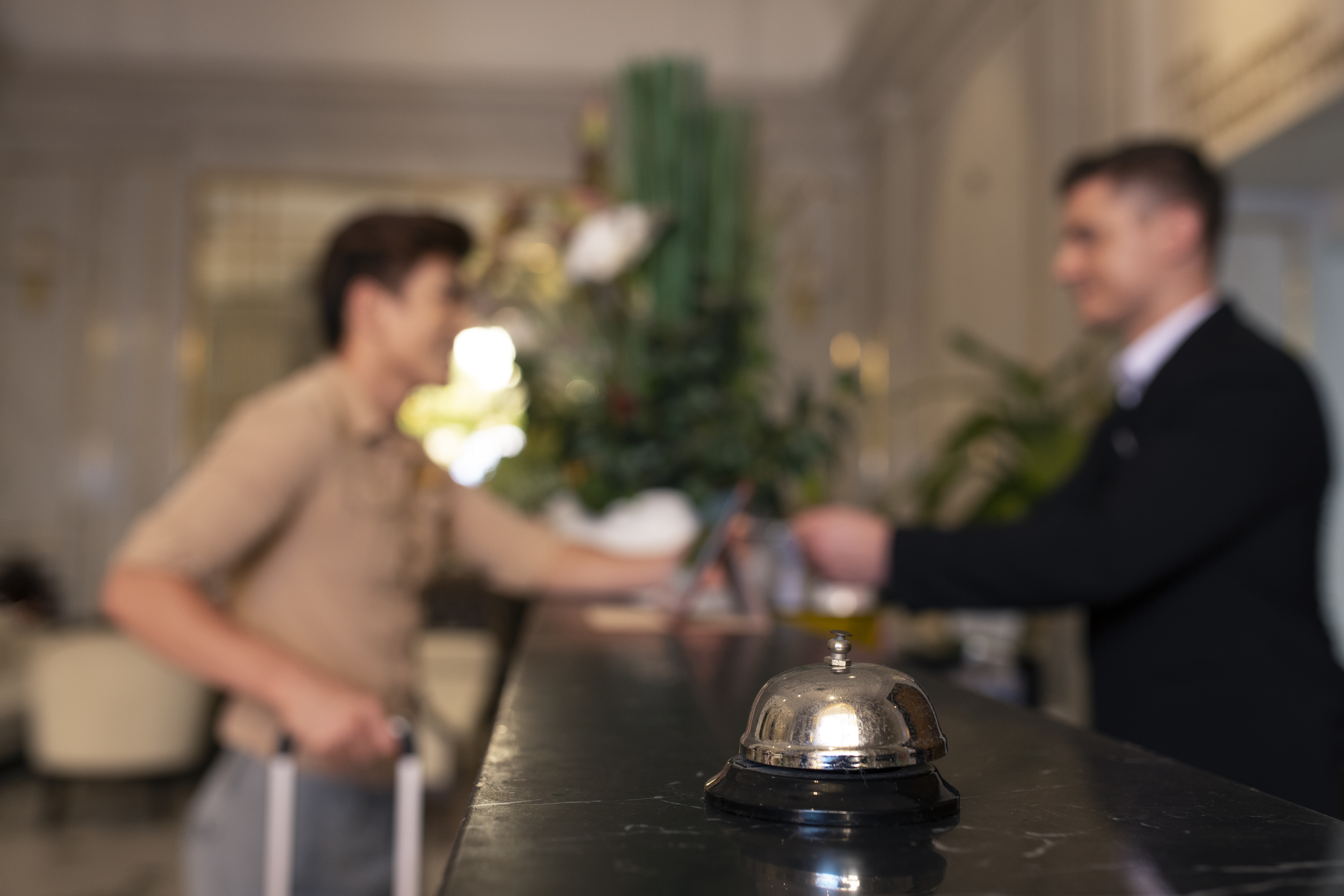 Hotel front desk employee assisting a guest, highlighting the importance of service and staff wellbeing